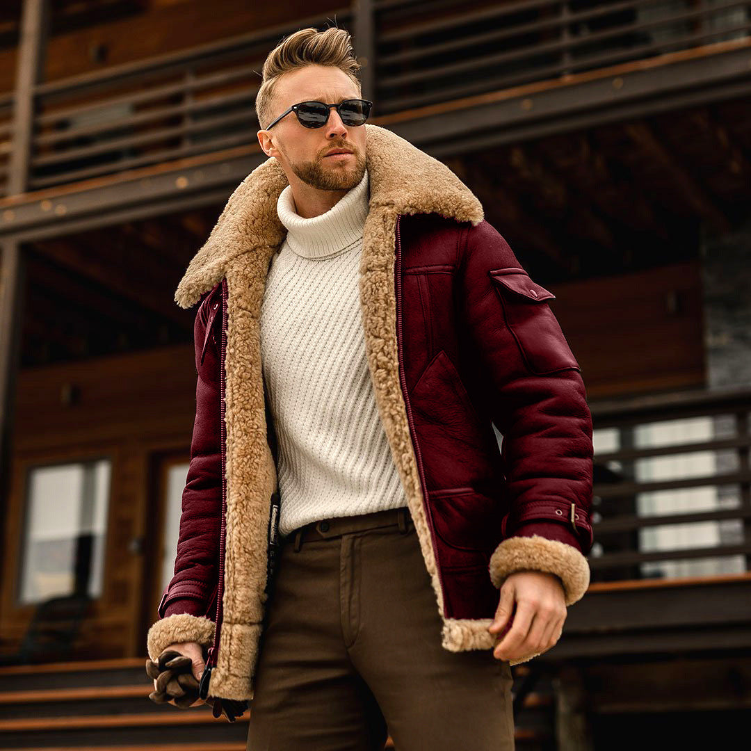 Man wearing a maroon shearling jacket in front of a wooden building.