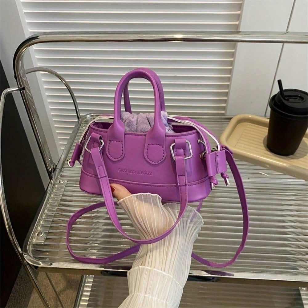 Purple handbag held by a person with a blurred background
