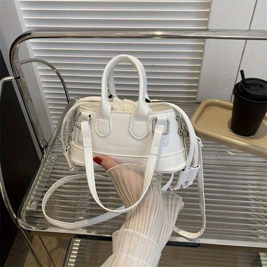 White handbag held by a person with a blurred background