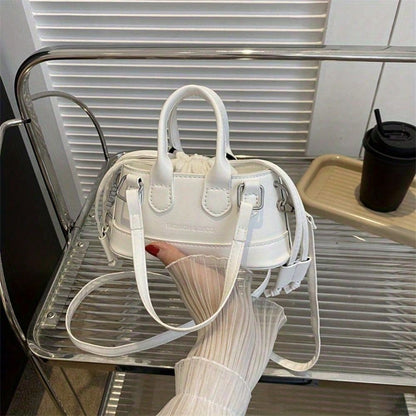 White handbag held by a person with a blurred background