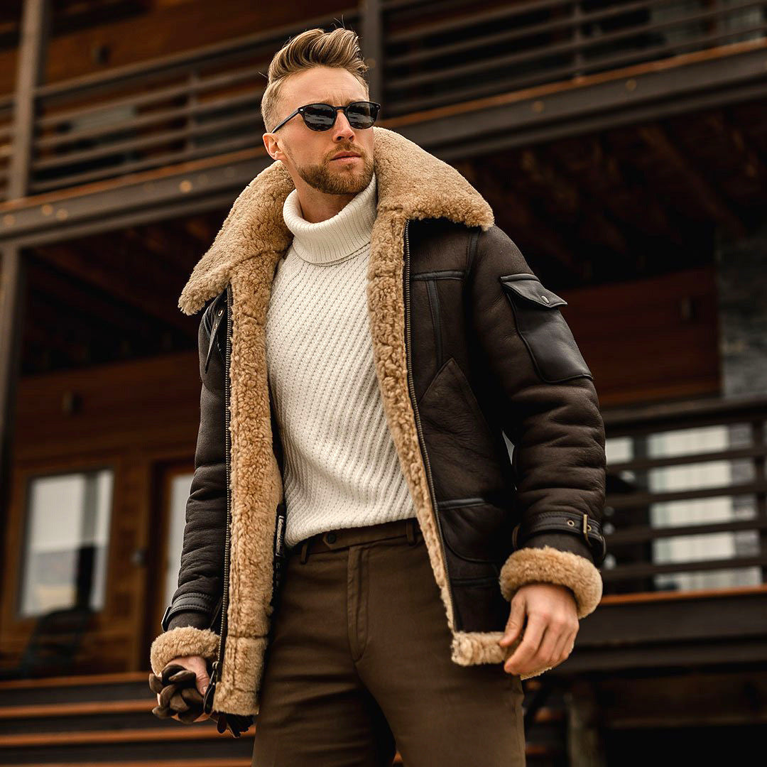 Man wearing a brown shearling jacket and sunglasses outdoors.
