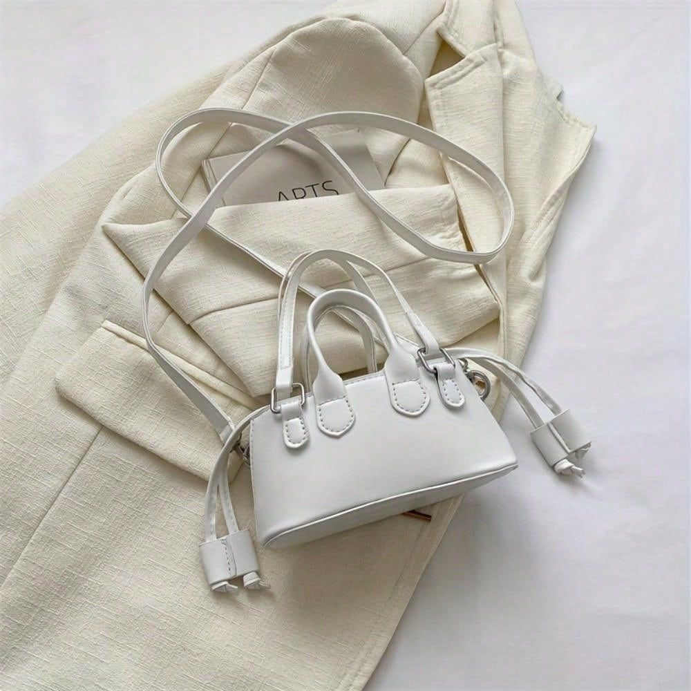 White handbag on a light beige fabric background